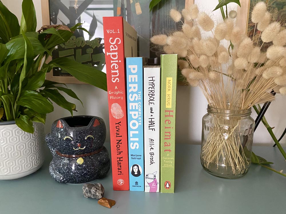 four graphic novels in a shelf, including "Heimat"